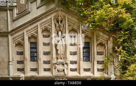 LONDON CITY OF LONDON STATUE AND WISTERIA OVER THE DOORWAY INTO THE PRIORY CHURCH ST BARTHOLOMEW THE GREAT Stock Photo