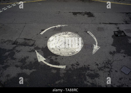 An aerial view of a painted road arrowed roundabout with no cars on could be used for analogy or concept image of being confused or lost etc. Stock Photo