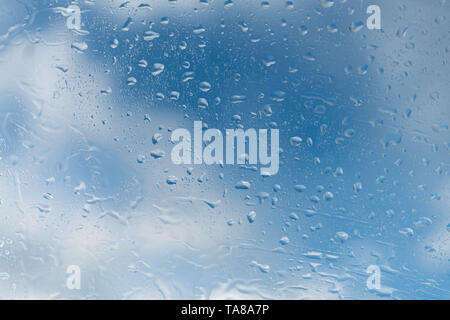 raindrops on a window a blue sky of a cloud Stock Photo