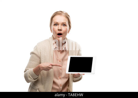 surprised middle aged woman pointing with finger at Digital Tablet with blank screen Isolated On White Stock Photo