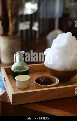 Delicious Japanese sweet shaved ice green tea on wooden table in japanese cafe Stock Photo