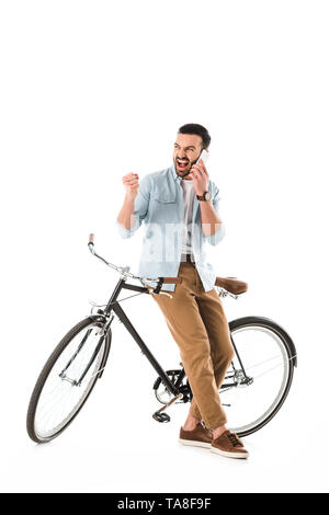 angry man with bicycle quarreling and showing fist while talking on smartphone isolated on white Stock Photo