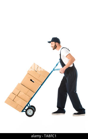 side view of delivery man transporting cardboard boxes loaded on hand truck isolated on white Stock Photo