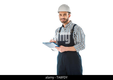 smiling construction worker writing on clipboard and looking at camera isolated on white Stock Photo