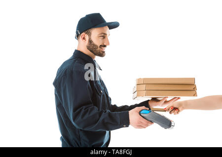 partial view of female hand with credit card near cheerful delivery man holding payment terminal and pizza boxes isolated on white Stock Photo