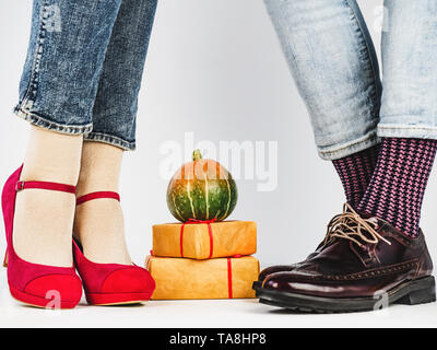 Men's and women's legs in fashionable shoes, colorful, multi-colored socks on a white, isolated background. Close-up. Concept of Style, Fashion and Be Stock Photo