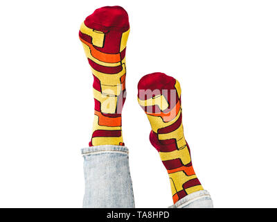 Men's legs, bright, multi-colored socks on a white, isolated background. Close-up. Concept of style, fashion and beauty Stock Photo