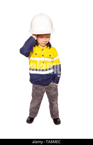 Young blond causacian boy scratching his head in disbelief role playing as a frustrated construction worker in a yellow and blue hi-viz shirt, boots,  Stock Photo