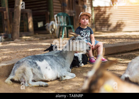 Girl and her beloved goats on the farm Stock Photo