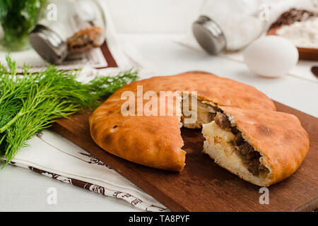 Traditional Russian sliced pie Kurnik close up on a slate board on the  table. vertical Stock Photo - Alamy