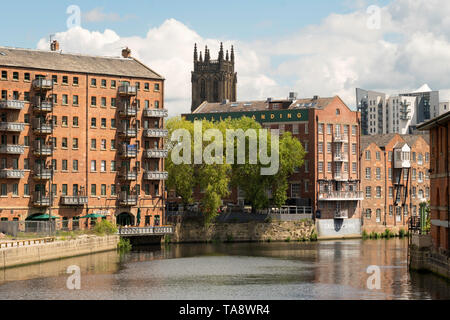 Warehouses converted into offices and apartments along the river Aire in  Leeds, Yorkshire, England, UK Stock Photo