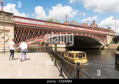 A Leeds Dock water taxi passes under the Crown Point Bridge over the river Aire in Leeds, Yorkshire, England, UK Stock Photo