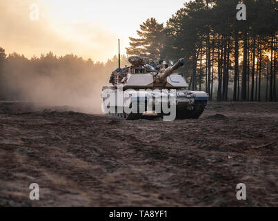 An M1A2 Abrams Tank from 1st Squadron, 4th Cavalry Regiment, 1st Armored Brigade Combat Team, 1st Infantry Division rolls out, as part of an Initial Ready Task Force (IRTF) exercise, at Johanna Range, Poland, May 20, 2019. An IRTF is similar to an Emergency Deployment Readiness Exercise (EDRE) but on a smaller scale. An IRTF is a no-notice, rapid-deployment exercise designed to test a unit's ability to alert, marshal, and deploy forces and equipment for contingency operations or an emergency disaster. (U.S. Army photo by Sgt. Thomas Mort) Stock Photo