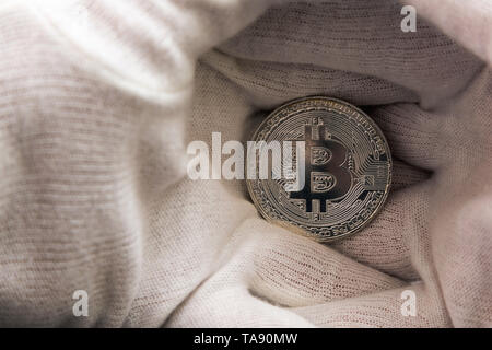 Man in white cloves holding Bitcoin coin between hand palms. Digital currency, block chain market Stock Photo