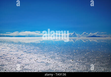 Uyuni Saltflats during rainy season. Mirror effect reflecting the clouds Stock Photo
