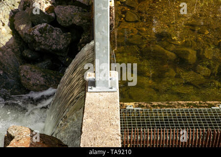 Spillway over a small dam close up. Water level difference. Regulation of the water level in the lake.