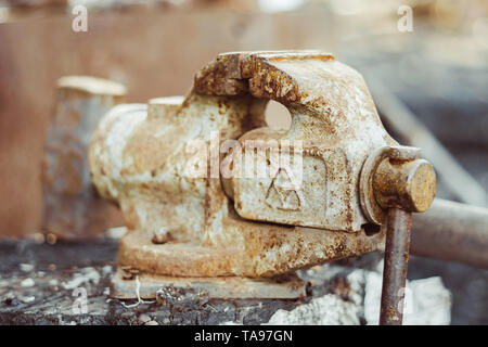 Close up on a red tabletop mounted vise grip with screw action grip and cast iron frame, in a machining workshop Stock Photo