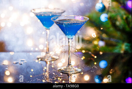 Christmas image of two wine glasses with blue cocktail and garland Stock Photo