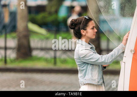 Tourist woman buys tickets for transport in Georgia. modern street machine for purchase of tickets for bus Stock Photo