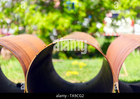 Big Steel Pipes on Road Verge in the City. Urban Infrastructure Construction and Replacement, City Development Concept. Stock Photo