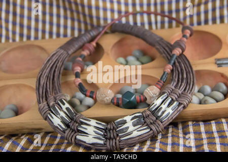 African tribal necklace with background made of African artifacts, private collection Stock Photo