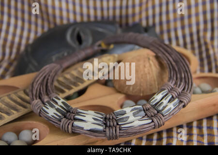 African tribal necklace with background made of African artifacts, private collection Stock Photo