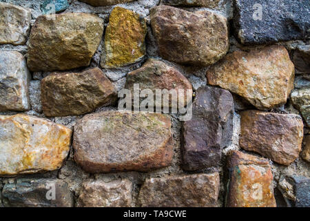 stone pattern in different sizes and colors, wall made of quarry rocks and cement, modern garden architecture Stock Photo