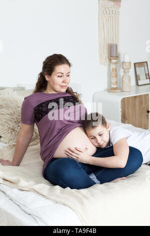Daughter bed naked Pregnant mother with naked tummy sitting on the bed with her teen daughter  who listening the baby, bedroom Stock Photo - Alamy