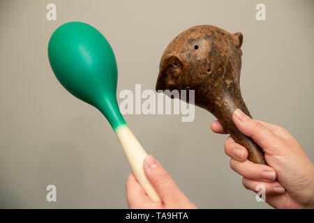 Iphofen, Germany. 21st May, 2019. During the construction work for the exhibition 'Sounds of Old America - Musical Instruments in Art and Culture', an employee of the Knauf Museum holds a small rattle (r) from Mexico (1300 A.D.) in her hands next to a rattle from modern times. From 26 May, the museum will be showing around 40 old musical instruments from Central and South America. According to the museum, the instruments will be on public display for the first time. The oldest is over 4000 years old, the youngest about 1400 years. Credit: Daniel Karmann/dpa/Alamy Live News Stock Photo