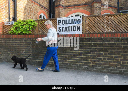 Wimbledon London, UK. 23rd May, 2019. A woman walks her dog to the polling station in Wimbledon to vote at the European Parliament Elections. It is forecast the Brexit Party of Nigel Farage is expected to do well at the expense of Labour and Conservative Parties at Elections which were not suppose to happen if Britain had left the European Union on 29 March  Credit: amer ghazzal/Alamy Live News Stock Photo