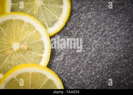 Lemon on dark / Fresh ripe lemons slice place on stone background citrus fruit top view Stock Photo