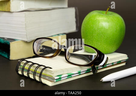 Studying, reading, education with books, glasses and green apple Stock Photo