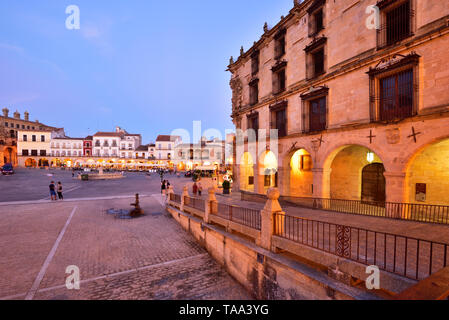 The Plaza Mayor in the evening. On the right, the Palacio de la Conquista (Palacio de los Orellana Toledo) built by the Pizarro family, dating back to Stock Photo