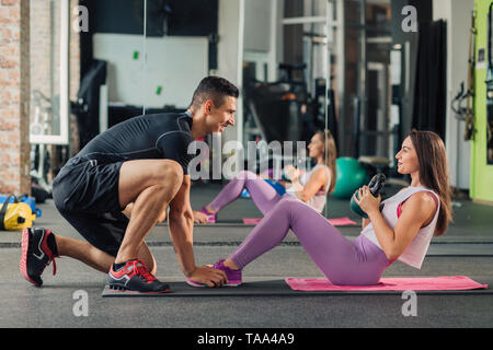 Young woman with personal trainer in the gym Stock Photo