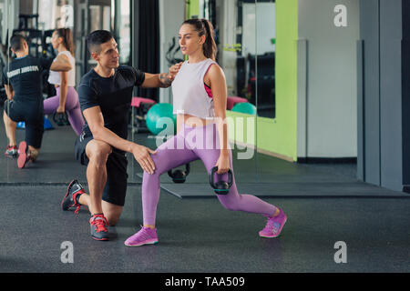Young woman with personal trainer in the gym Stock Photo