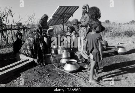woman collecting water from solar energy operated water pump, madhya pradesh, India, Asia Stock Photo