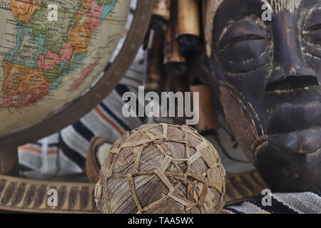 Retro globe with African artifacts and Tribal mask from Uganda Stock Photo