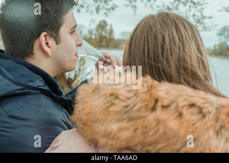 A young couple sits relaxing on a river Stock Photo