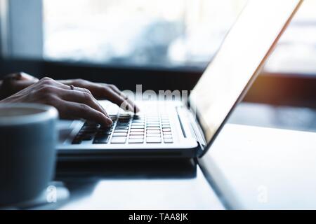 woman using laptop, searching web, browsing information, having workplace at home or in creative office or cafe. Stock Photo