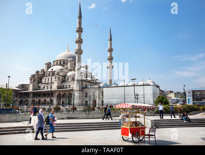 ISTANBUL, TURKEY - MAY 23, 2016: Street Vendor and tourist walking in front of Yeni Cami, New Mosque near Galata Bridge Stock Photo