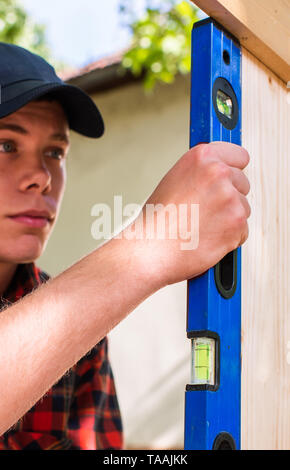Young handsome man using water spirit level in his work Stock Photo