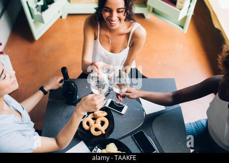 three young multiracial friends having fun and drinking together – friendship, cheerful, celebration Stock Photo