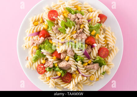 Pasta salad with vegetables on pink background Top view. Close up Stock Photo