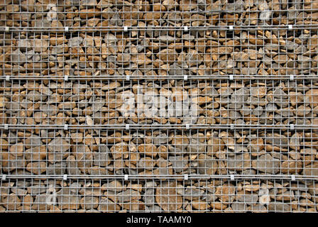 Barrier made from various sized stones and pebbles, held by steel mesh, Paris, France Stock Photo