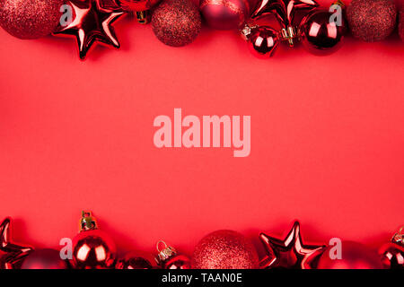 Christmas background. Red glittering christmas baubles lying on a red background Stock Photo
