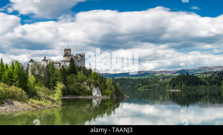Panoramic view at Niedzica castle over Czorsztyn lake in polish Pieniny mountains. Smooth lake water and clouds at blue sky. Stock Photo