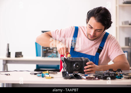 Young male contractor repairing computer Stock Photo