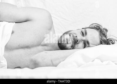 Late morning overslept. Man handsome guy lay in bed in morning. Tips on how to wake up feeling fresh and energetic. Morning routine tips to feel good all day. How to get up in morning feeling fresh. Stock Photo