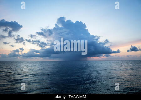 sunset, sea, the sun is covered with clouds. Open ocean view Stock Photo