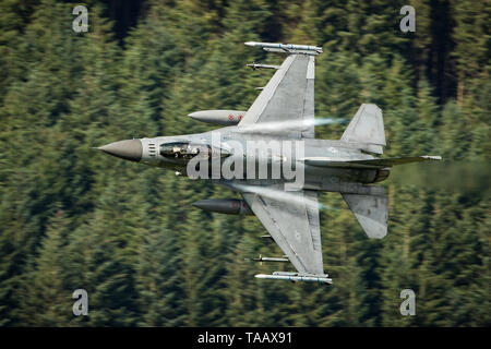 USAF F-16 fighter jet flying low level through the Mach Loop in Wales, UK Stock Photo